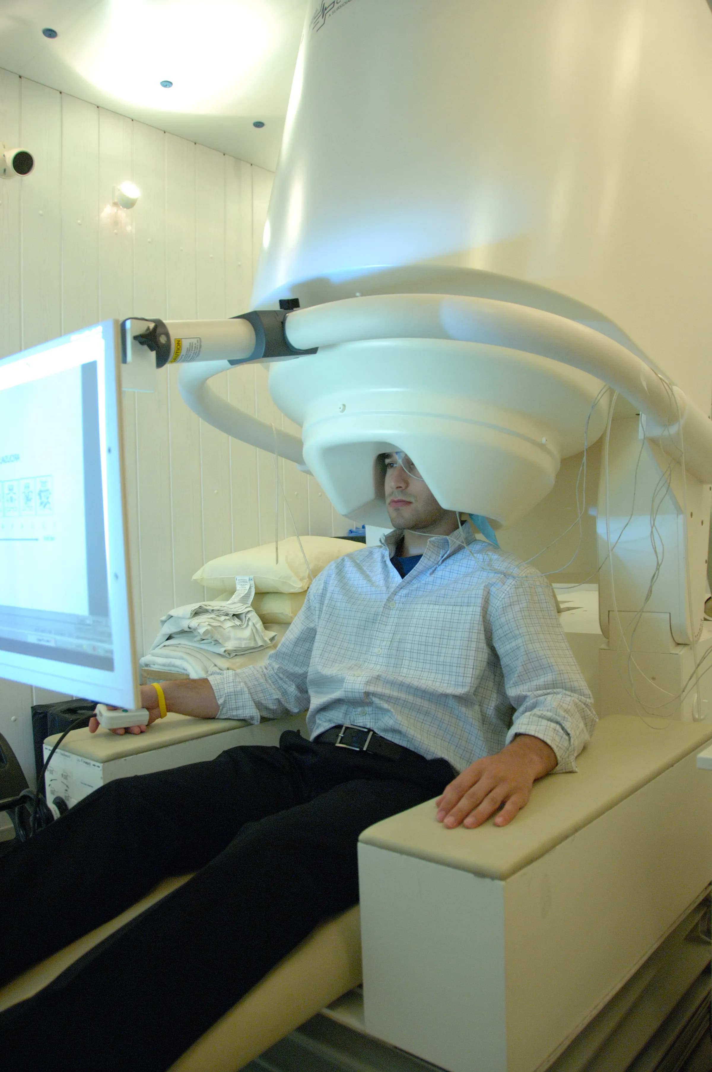 A person seated in a magnetoencephalography scanner that records the brain’s magnetic fields.